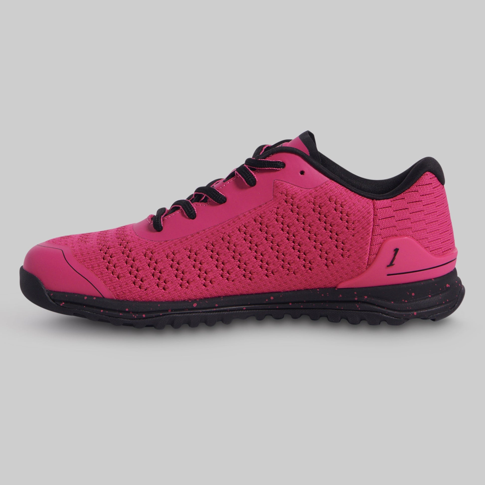 Pink athletic shoe with black accents on a gray background