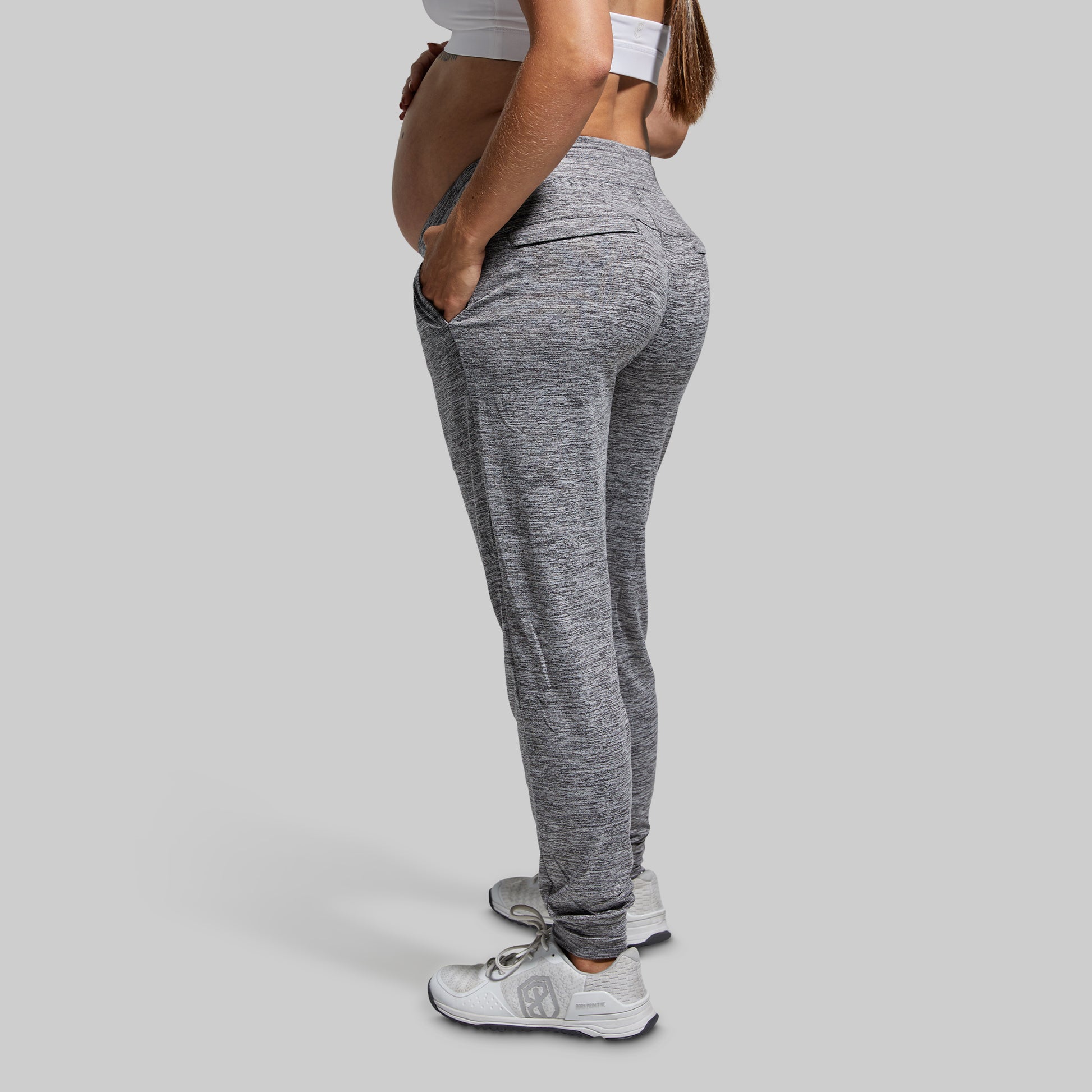 Person wearing gray jogger pants on a plain background