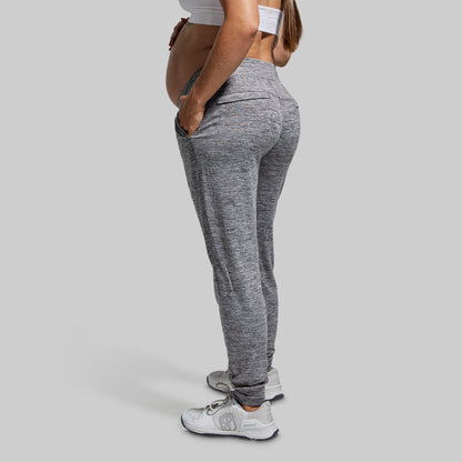 Person wearing gray jogger pants on a plain background