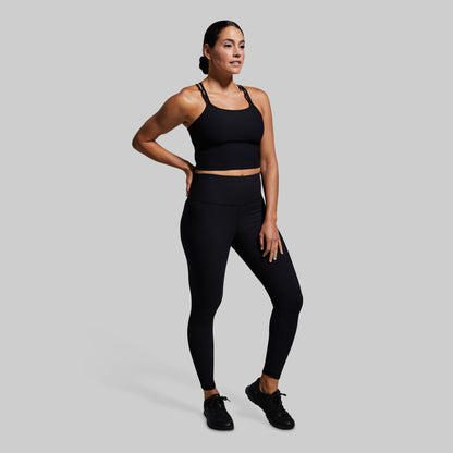 Woman wearing a black athletic outfit on a gray background