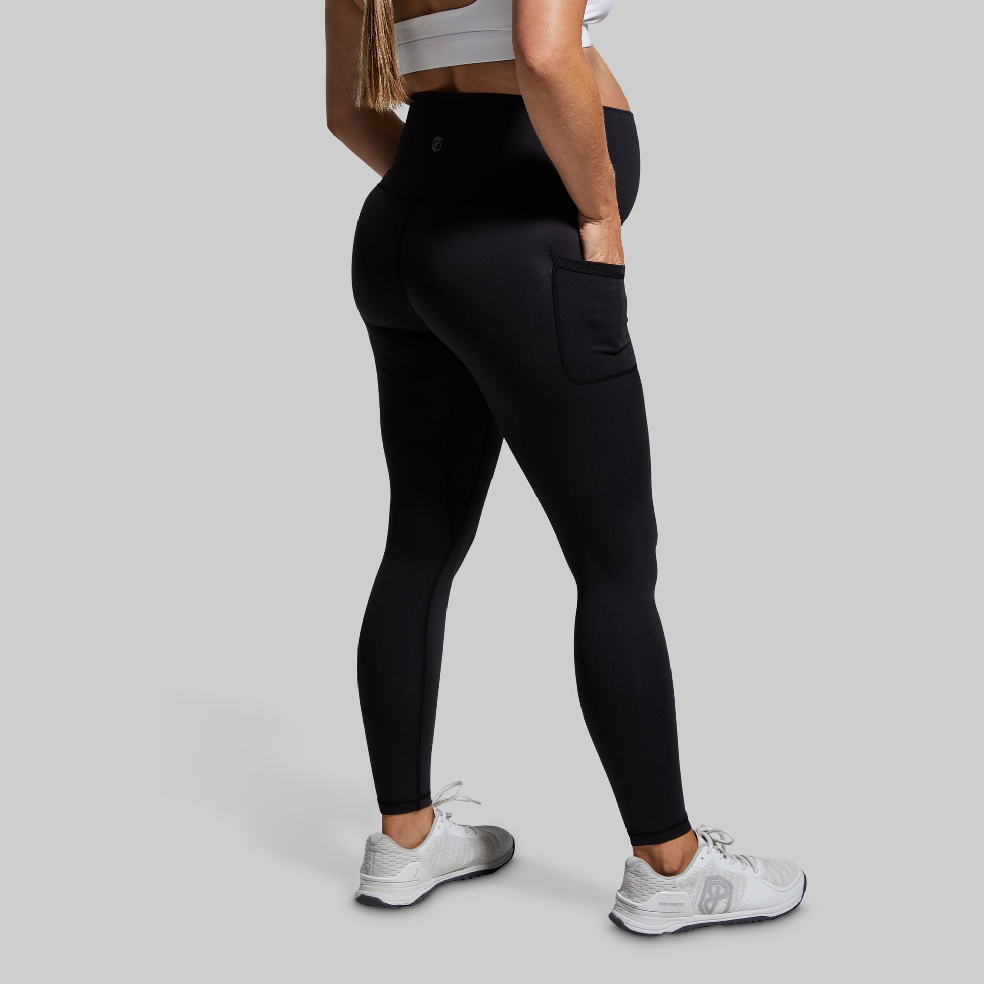 Person wearing black leggings on a gray background