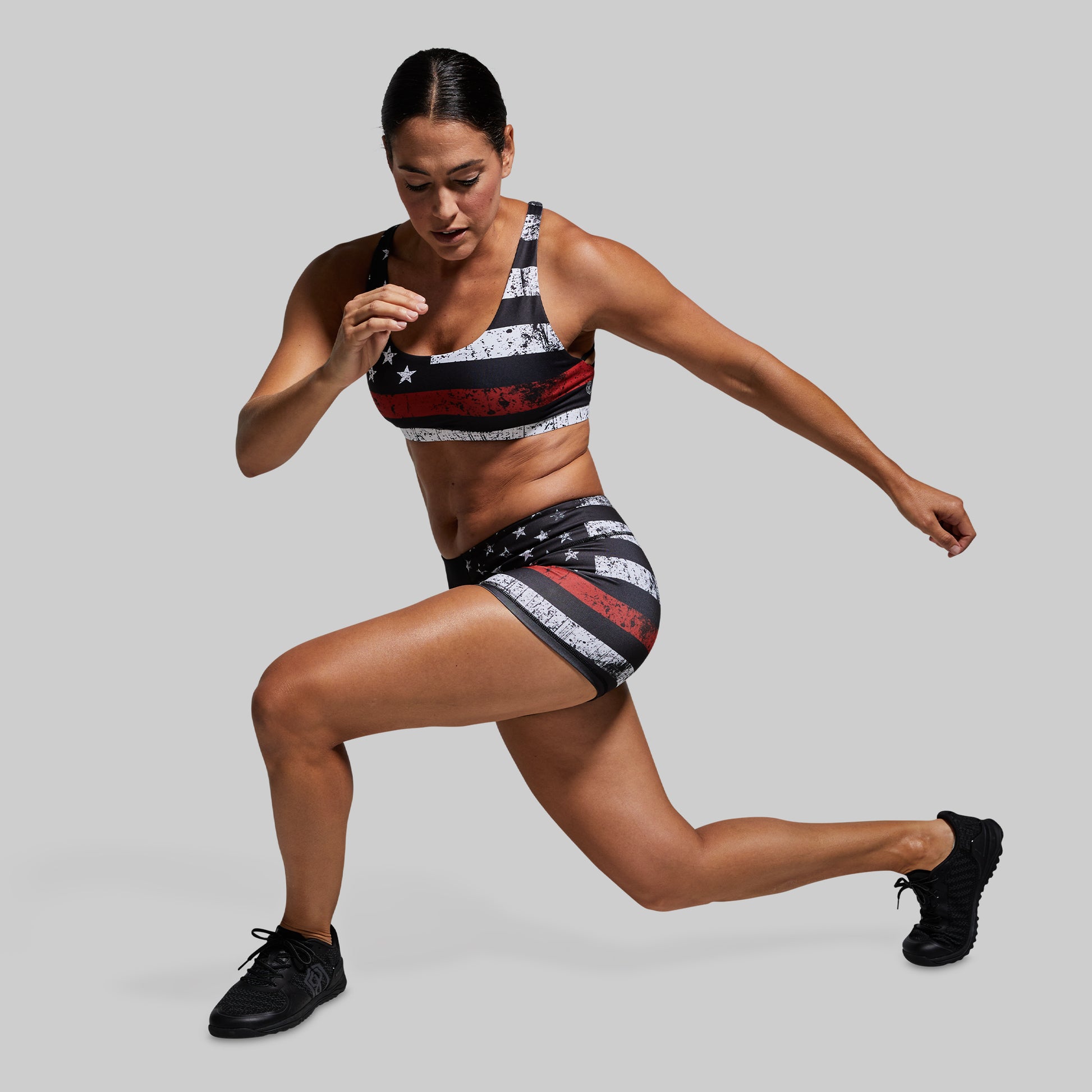 Woman in athletic wear with American flag design on a gray background