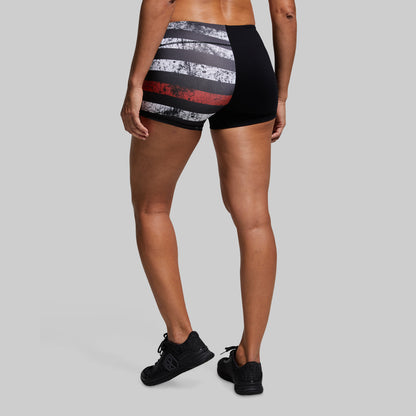 Person wearing black and red striped athletic shorts on a gray background