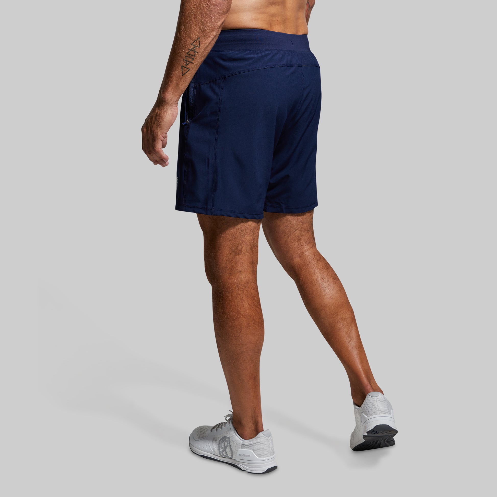 Person wearing navy athletic shorts on a gray background