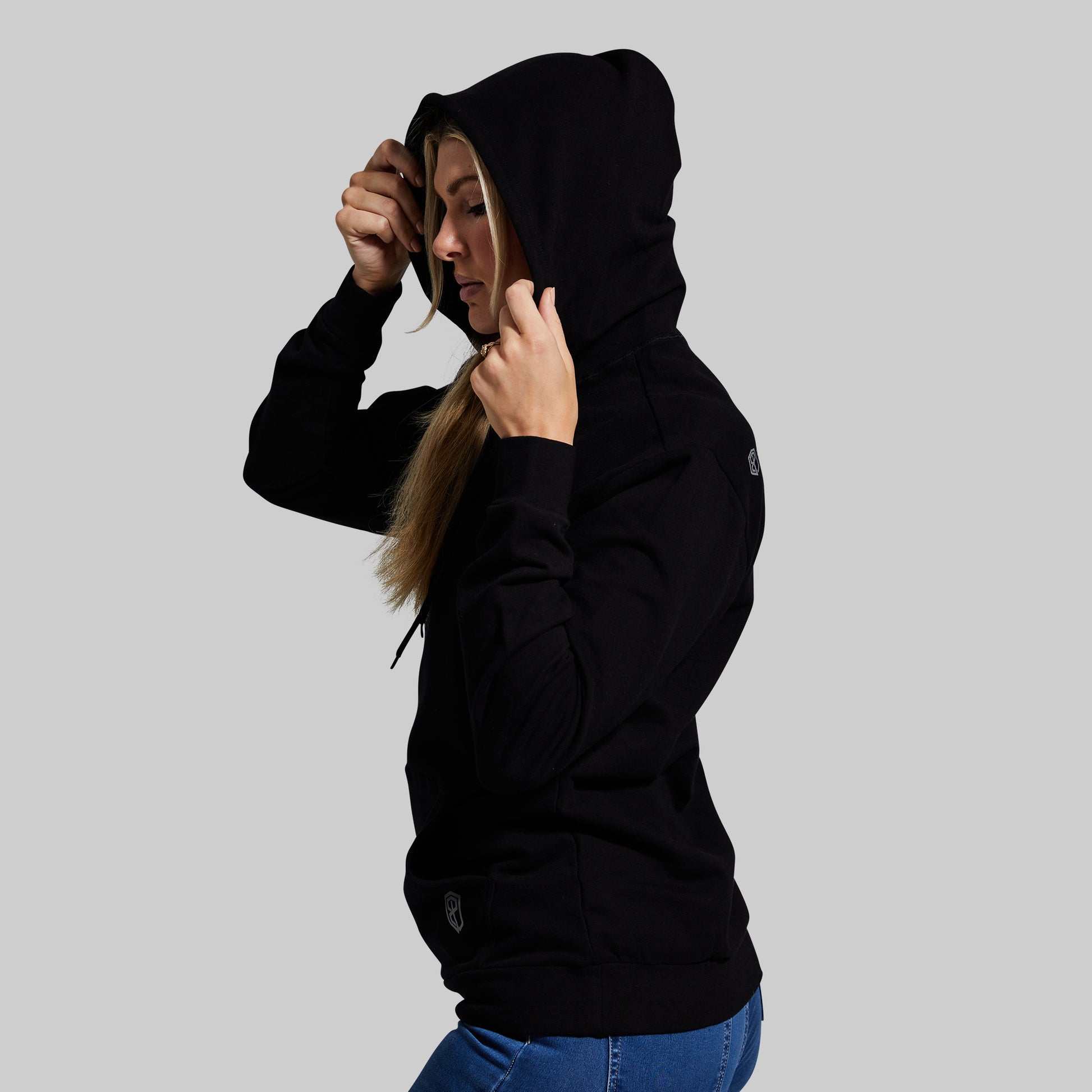 Person wearing a black hoodie on a gray background