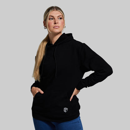 Person wearing a black hoodie with a logo on a gray background