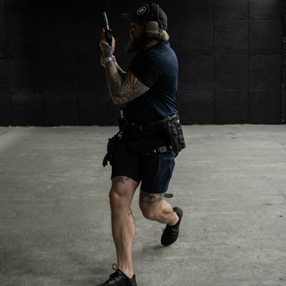 Person in tactical gear holding a weapon in an indoor setting