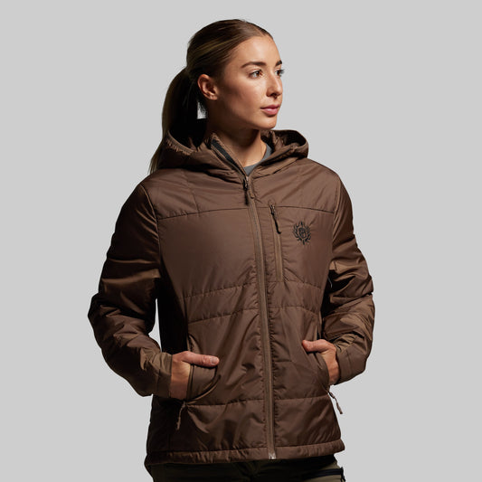 Woman wearing a brown puffer jacket on a gray background