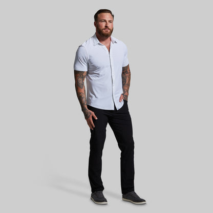 Man wearing a white shirt and black pants on a gray background