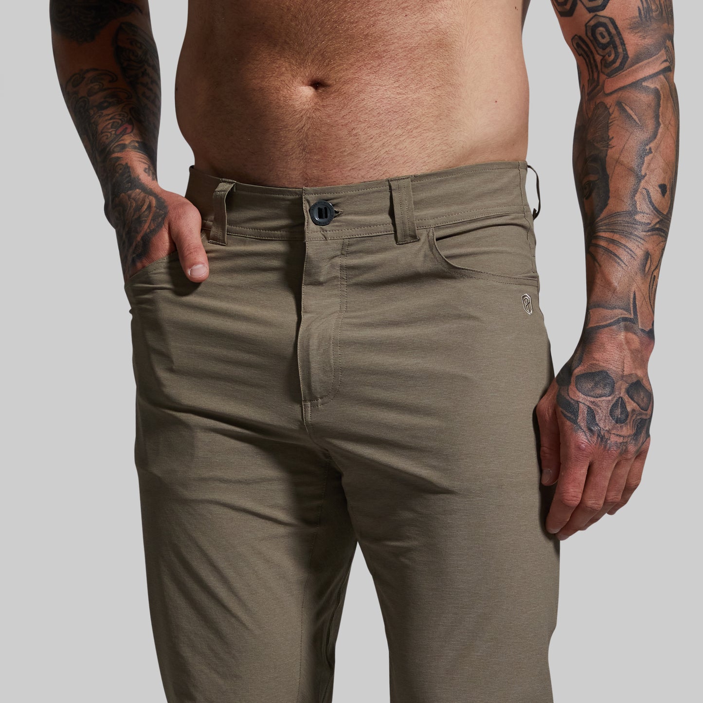 Person wearing light brown pants with a plain background