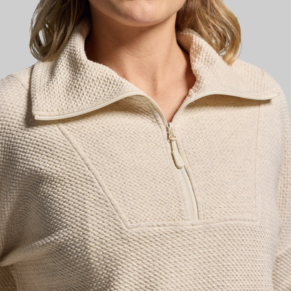 Close-up of beige, textured quarter-zip sweatshirt.