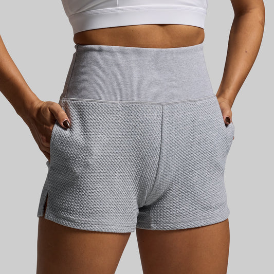 Gray textured shorts worn by a person on a plain background