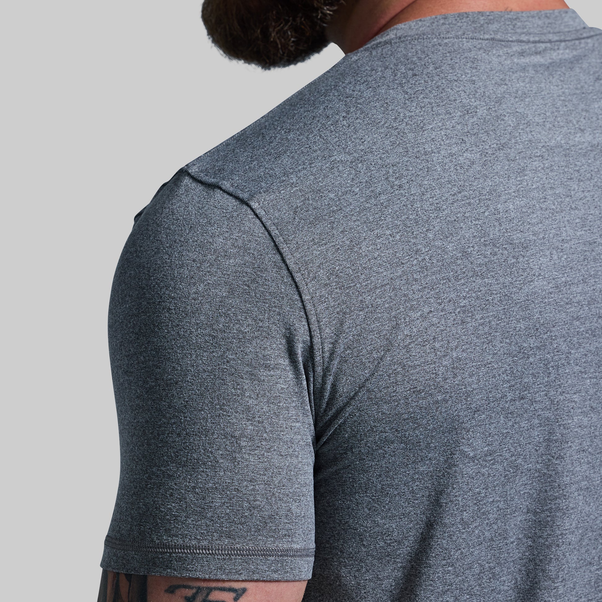 Gray t-shirt worn by a person on a light gray background