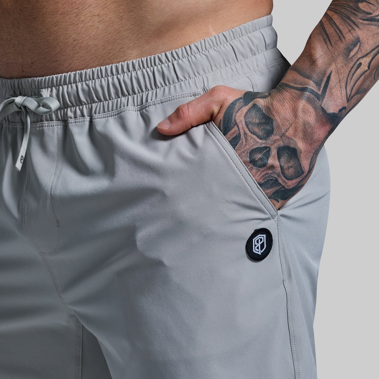 Gray athletic shorts with a brand logo on a neutral background
