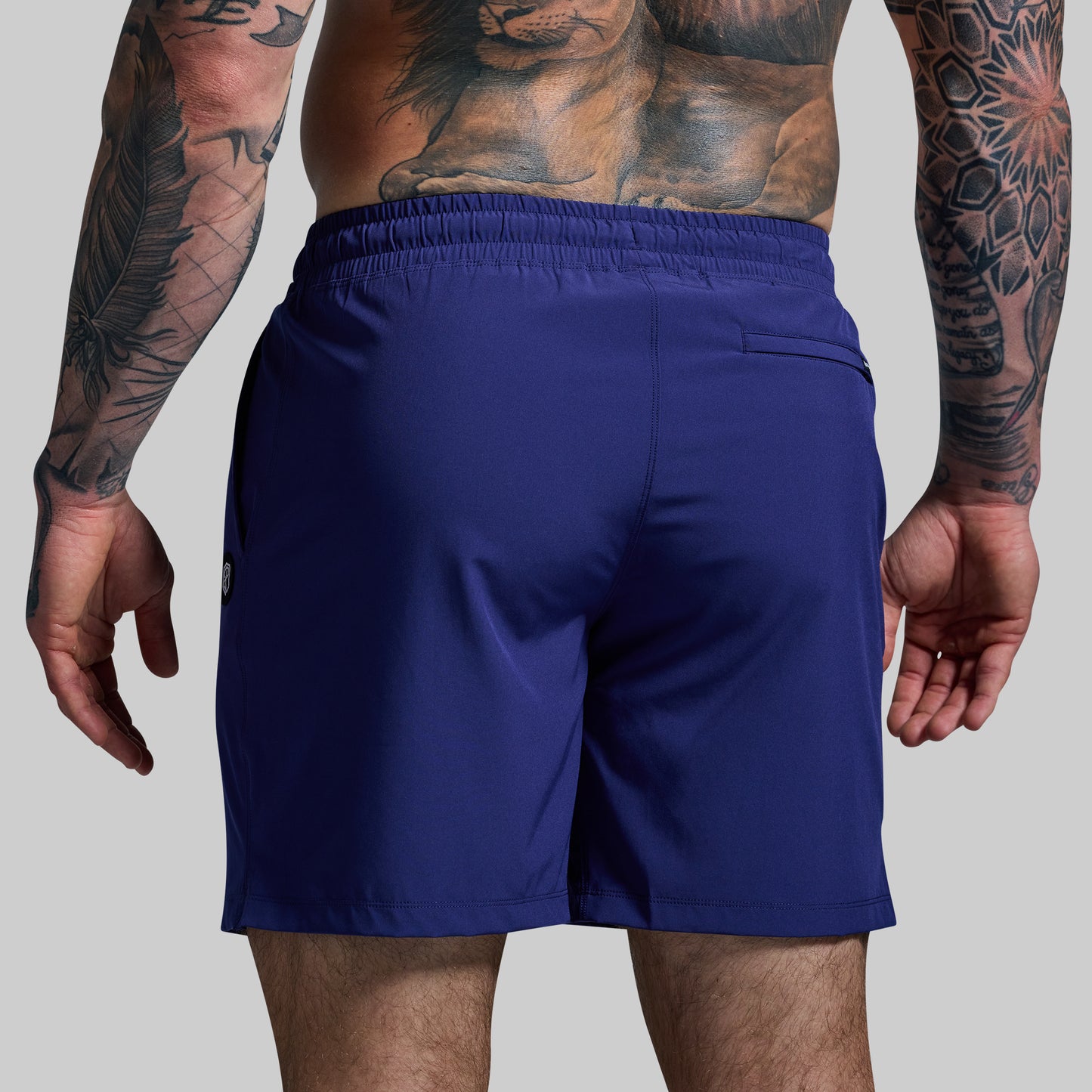 Person wearing blue shorts with a plain background