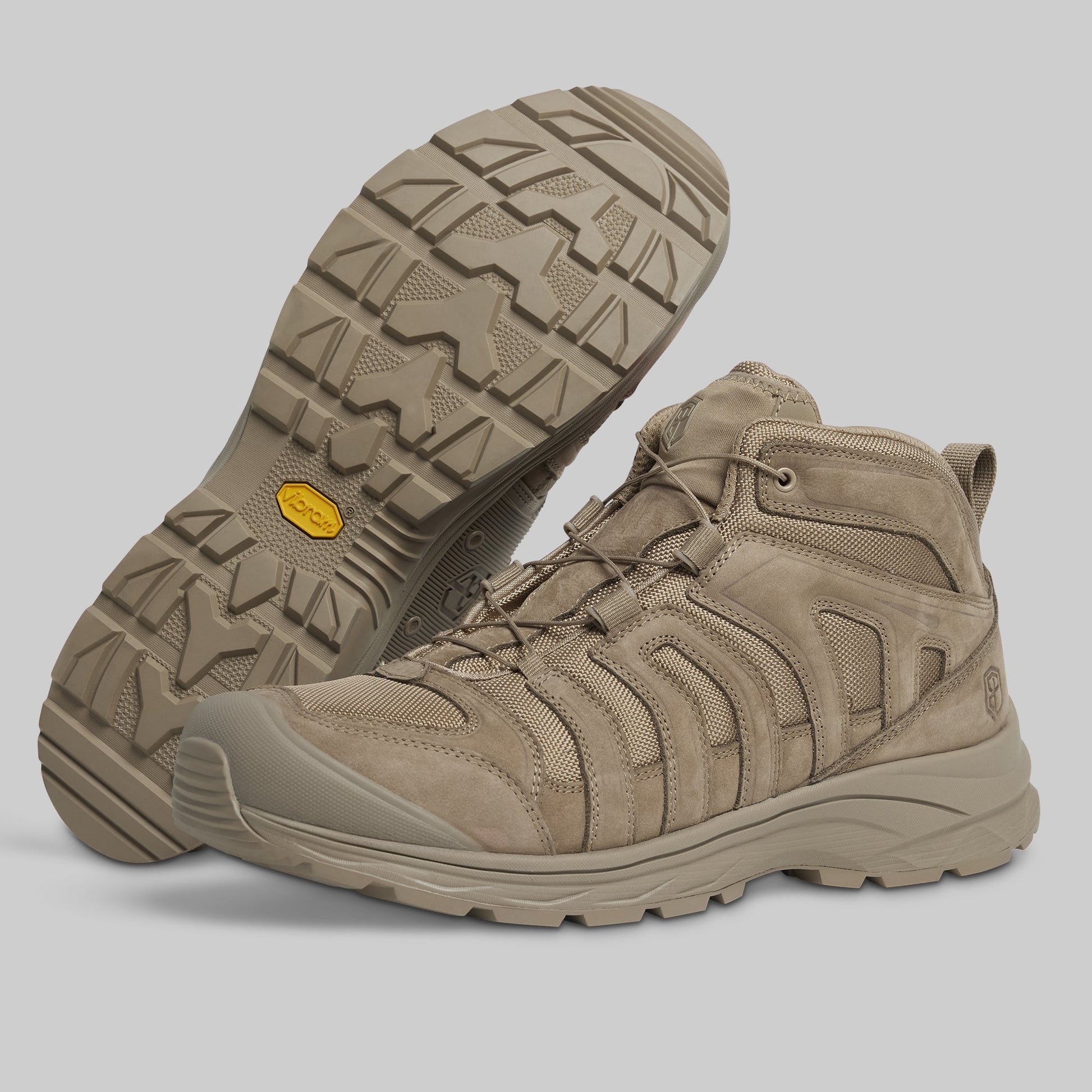 Pair of tan tactical boots on a gray background