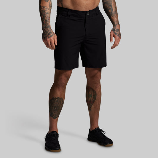 Person wearing black shorts on a gray background