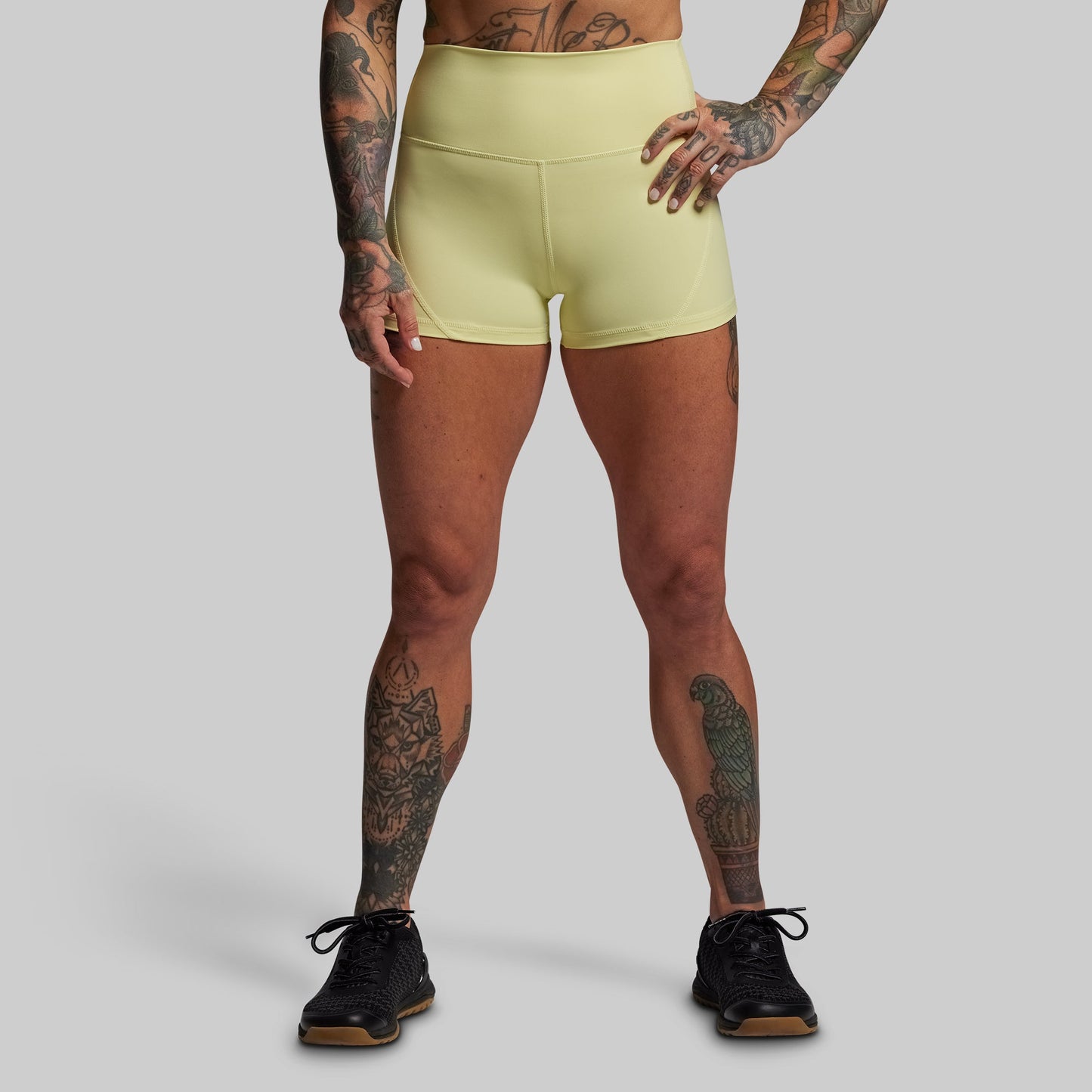 Person wearing light green athletic shorts on a gray background