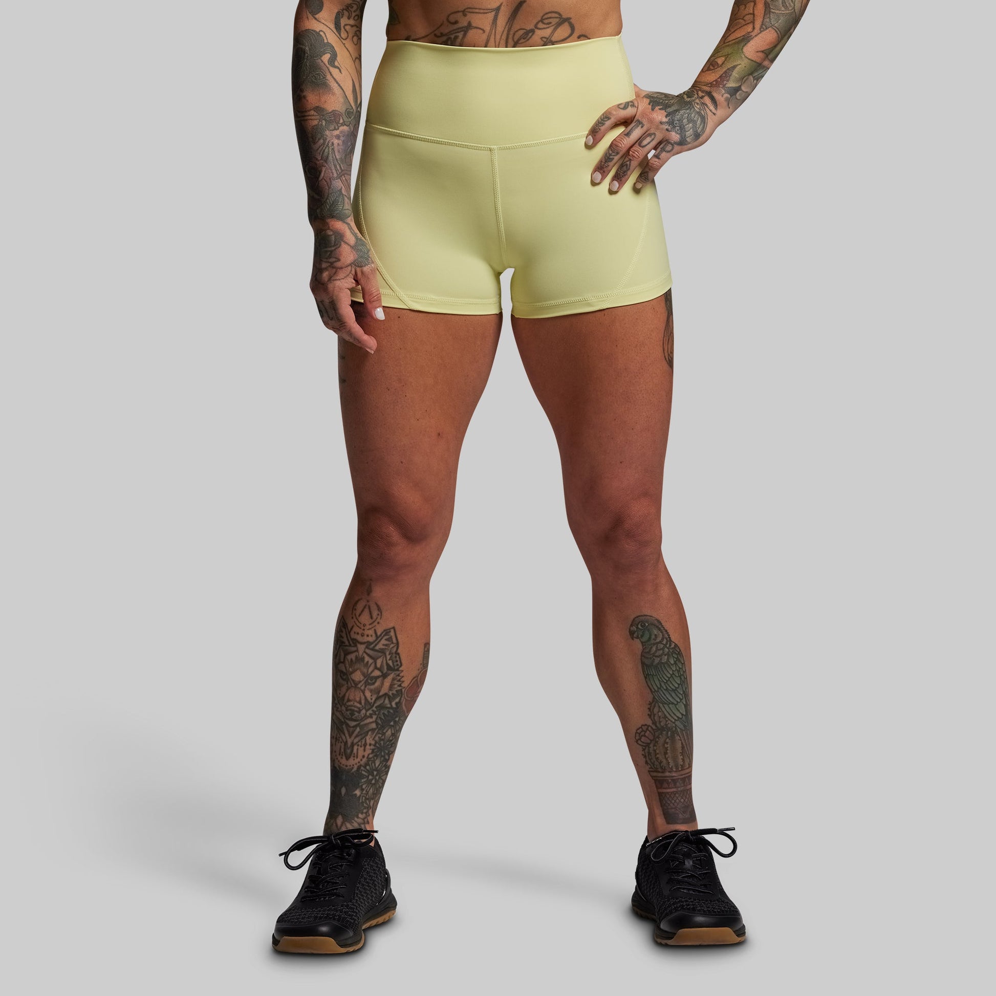 Person wearing light green athletic shorts on a gray background