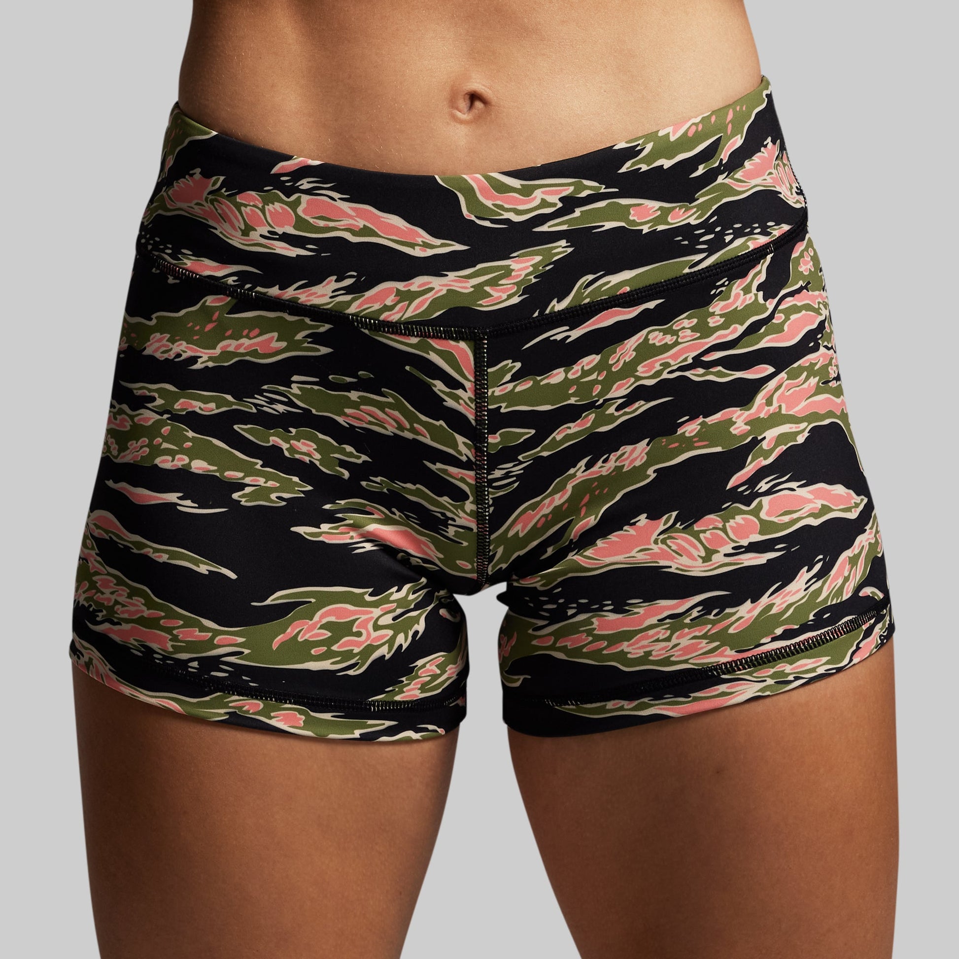 Camouflage-patterned shorts worn by a person on a gray background