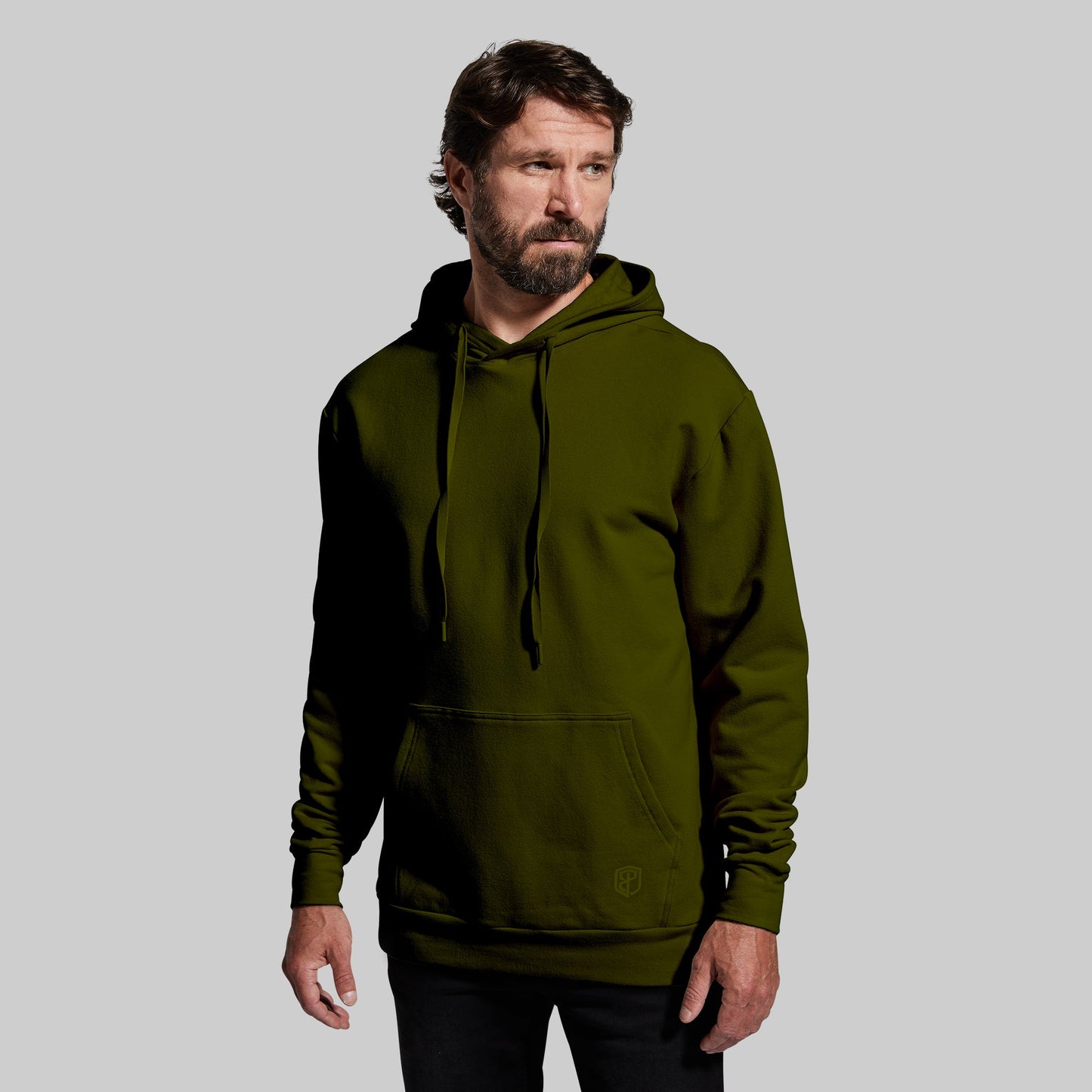 Man wearing a green hoodie against a gray background