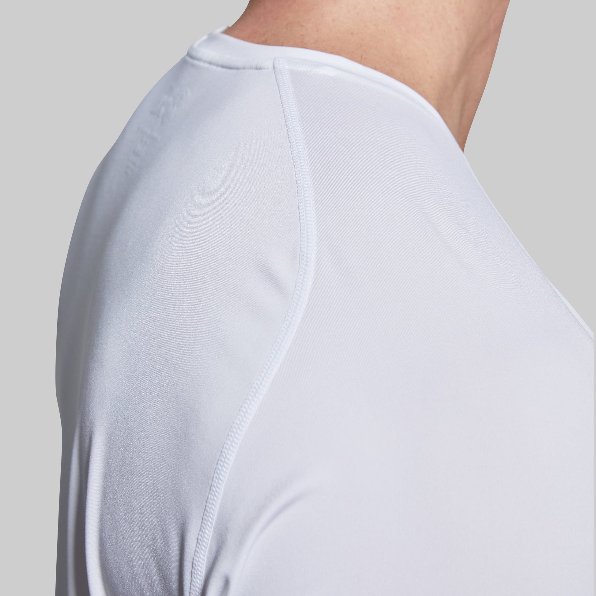Close-up of a white t-shirt seam on shoulder worn by a person.