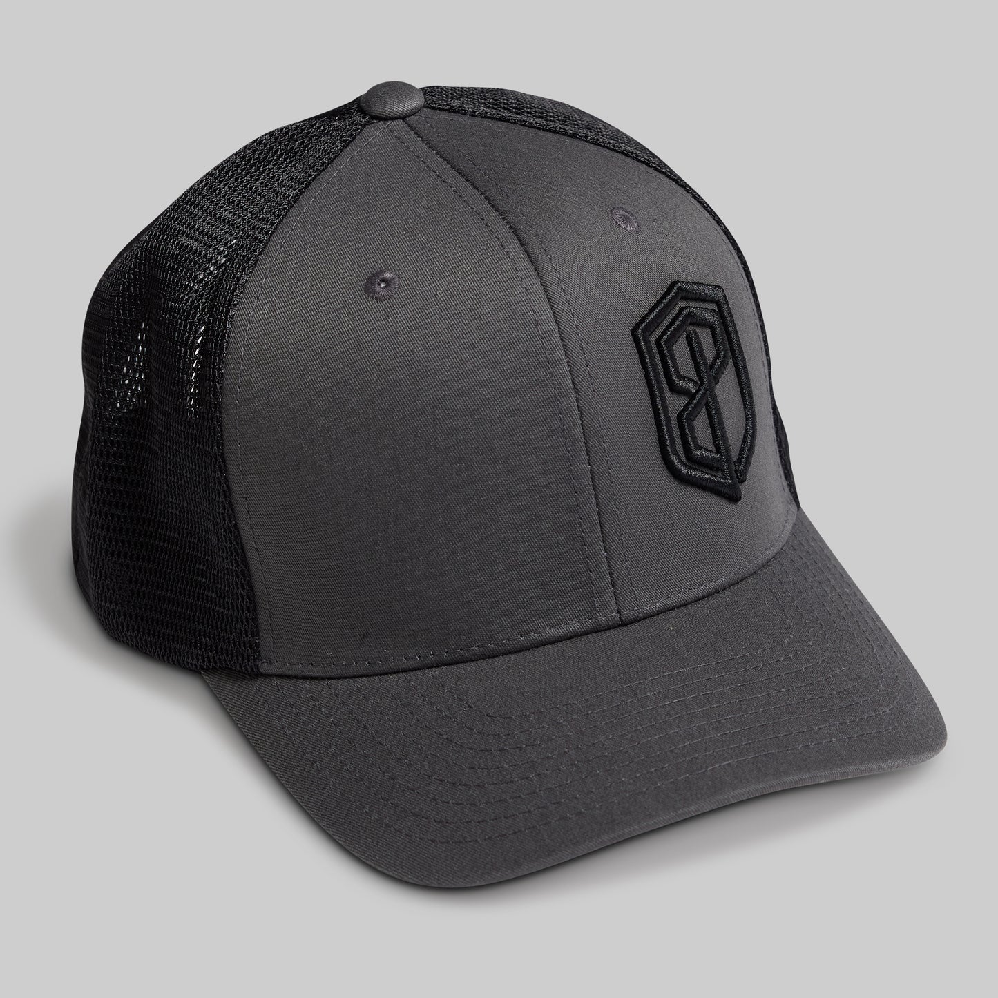 Gray cap with black mesh back and logo on a light gray background