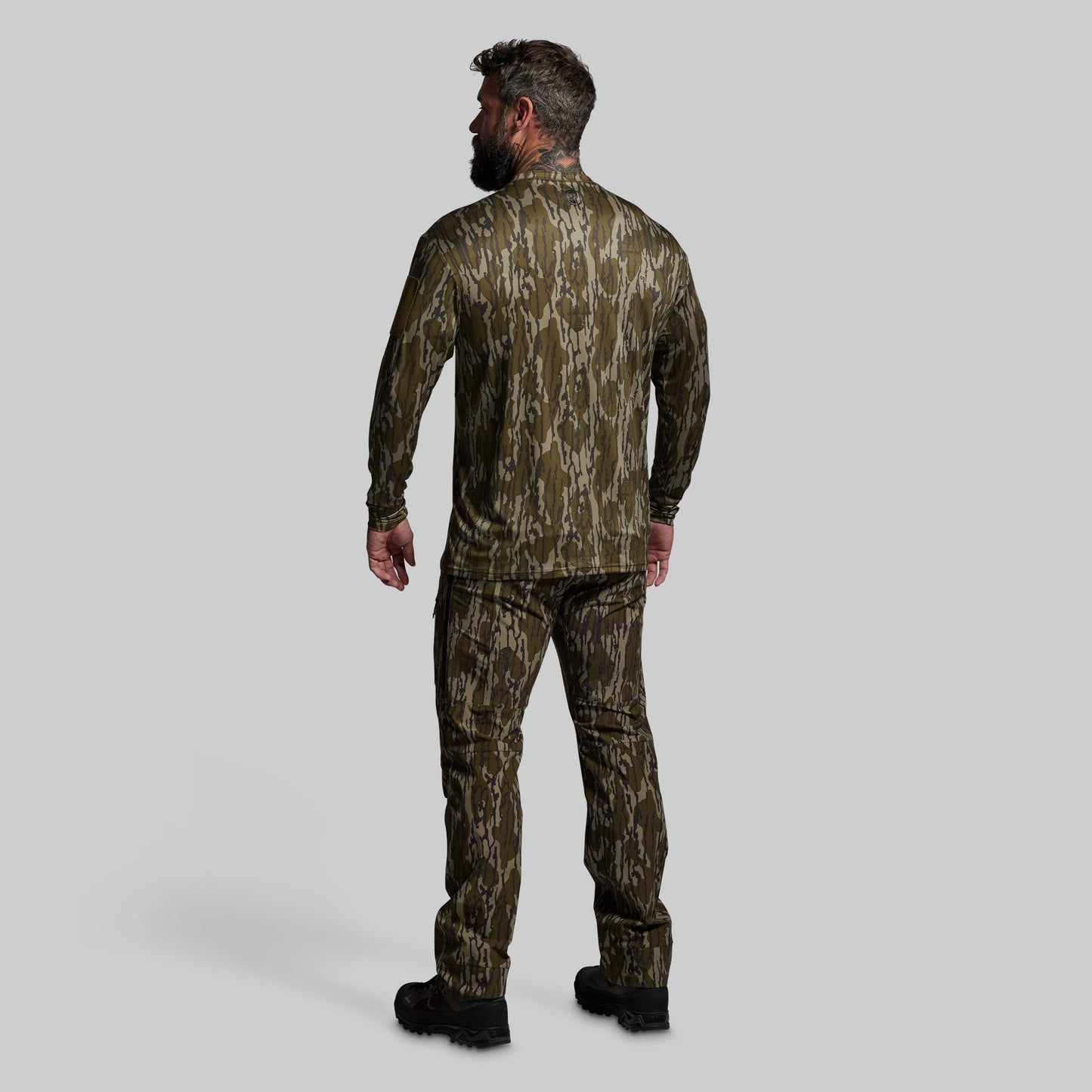 Man wearing a camouflage outfit on a gray background