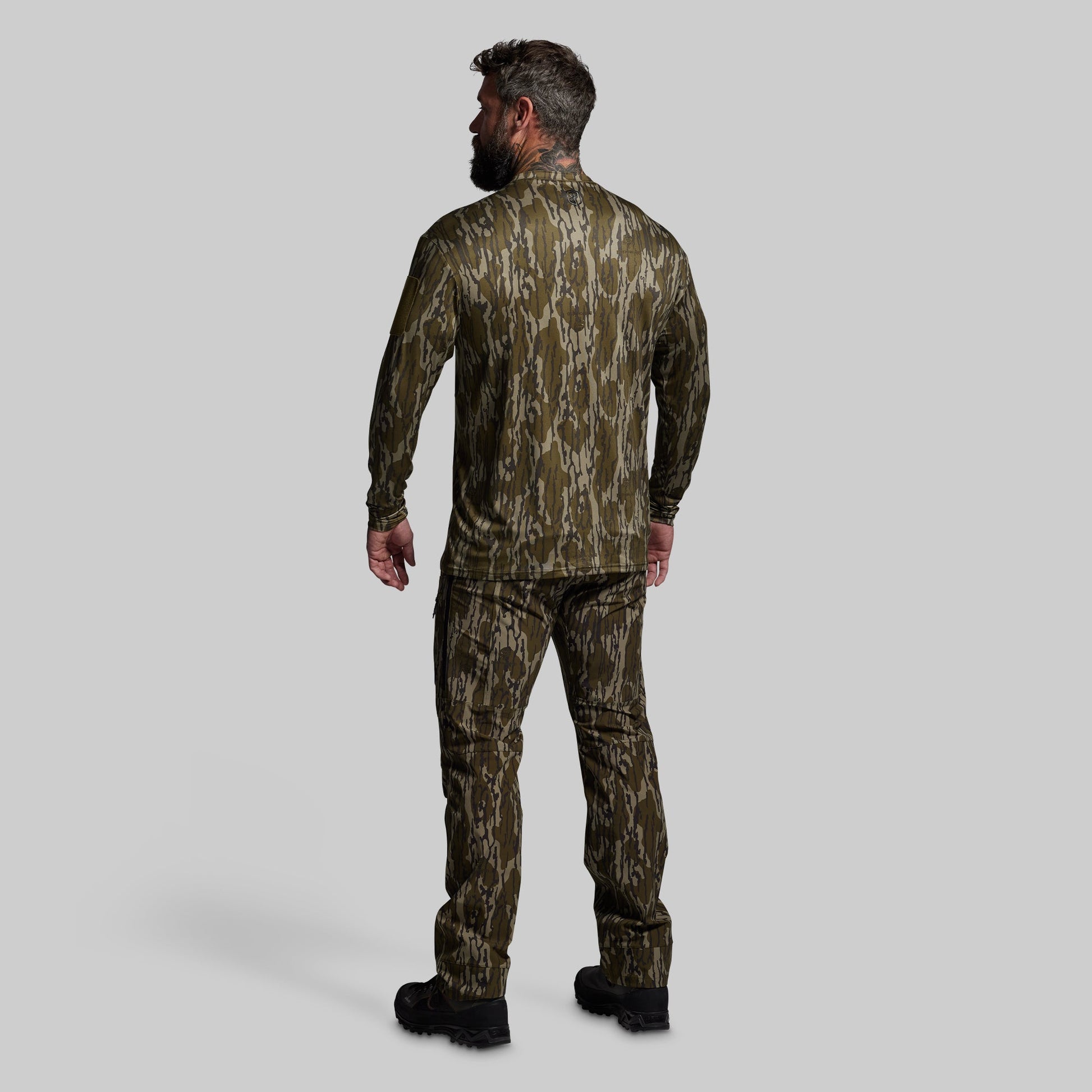 Man wearing a camouflage outfit on a gray background