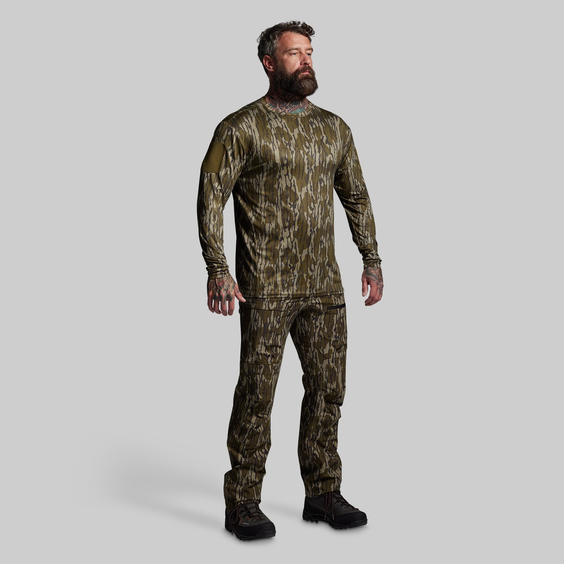 Man wearing a camouflage outfit on a gray background