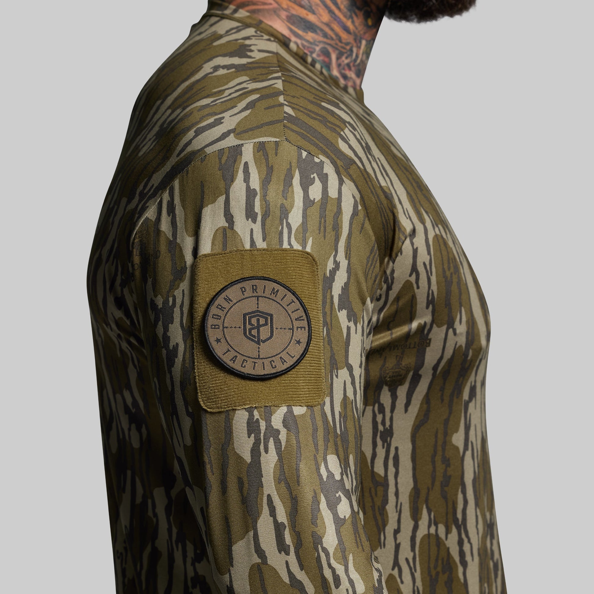 Camouflage shirt with a patch on the sleeve against a gray background