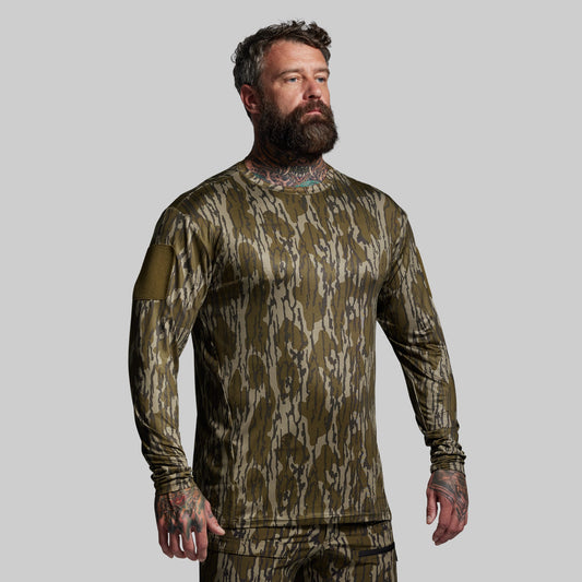 Man wearing a camouflage long-sleeve shirt on a gray background