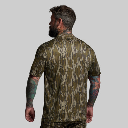 Man wearing a camouflage shirt on a gray background