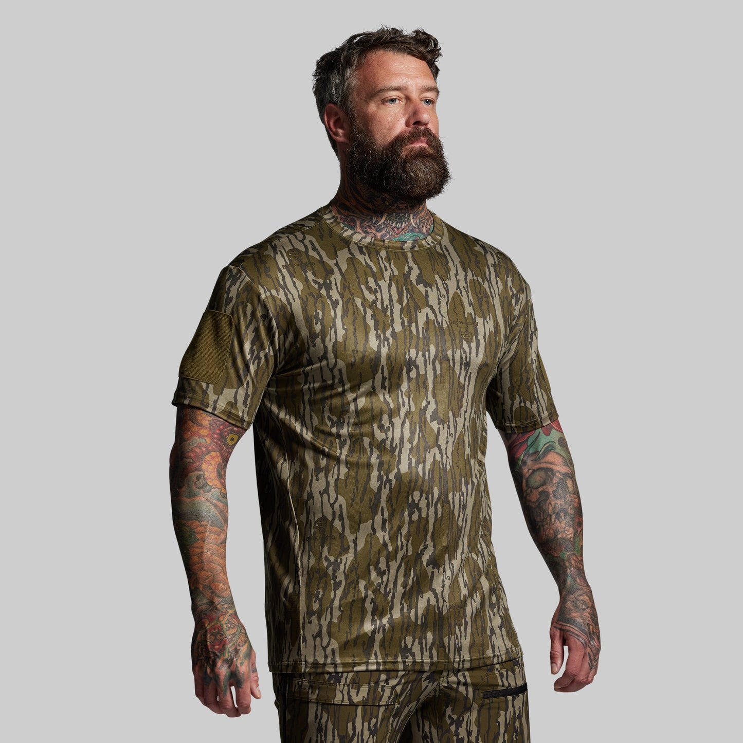 Man wearing a camouflage short sleeve on a gray background