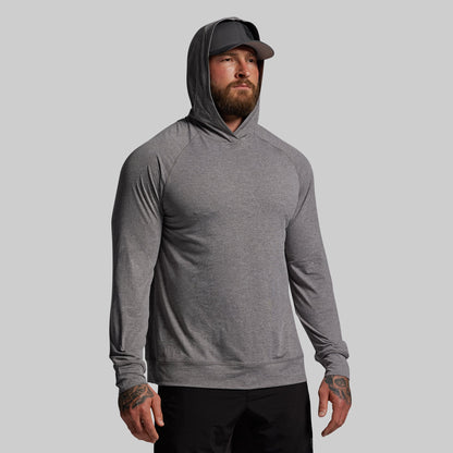 Man wearing a gray hoodie and cap on a light gray background