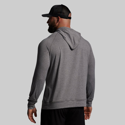 Man wearing a gray hoodie and black cap on a light gray background