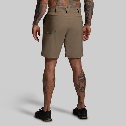 Person wearing brown shorts on a gray background