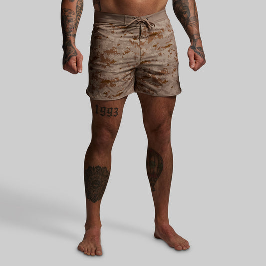 Person wearing camouflage shorts on a plain background