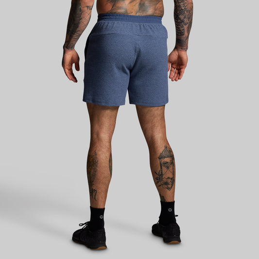 Person wearing blue shorts on a gray background
