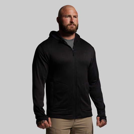 Man wearing a black hoodie against a gray background