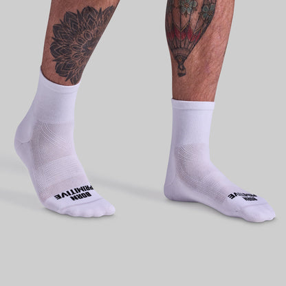 White socks with brand logo worn by a person on a light gray background