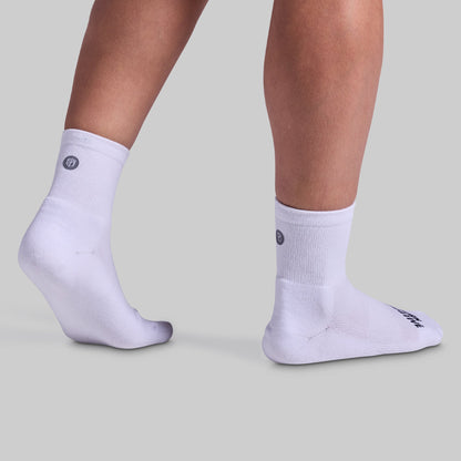 A pair of white performance half crew socks, featuring a cushioned panel at the heel and a brand logo near the top.