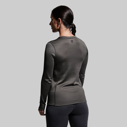 Woman wearing a gray long-sleeve base layer top against a plain background