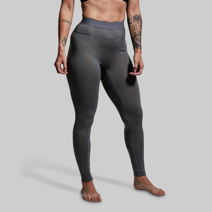 Person wearing gray base layer bottoms on a plain background