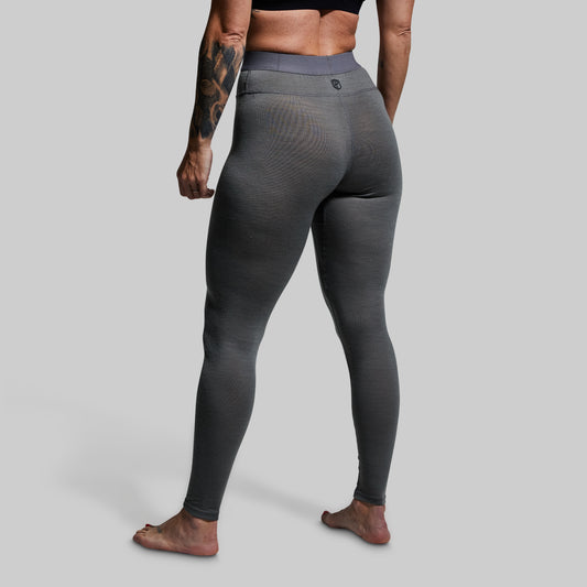 Person wearing gray base layer bottoms on a plain background