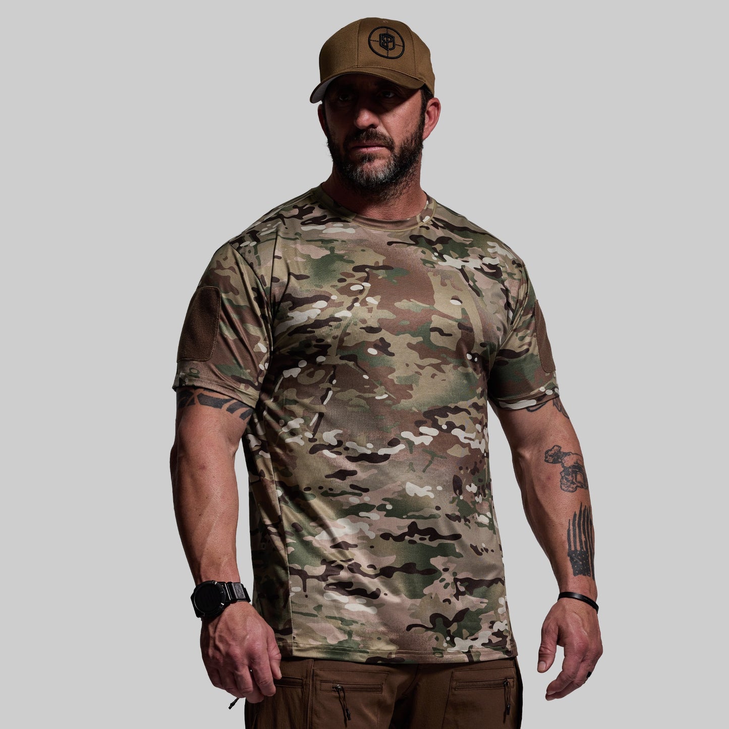 Man wearing a camouflage t-shirt and cap on a gray background