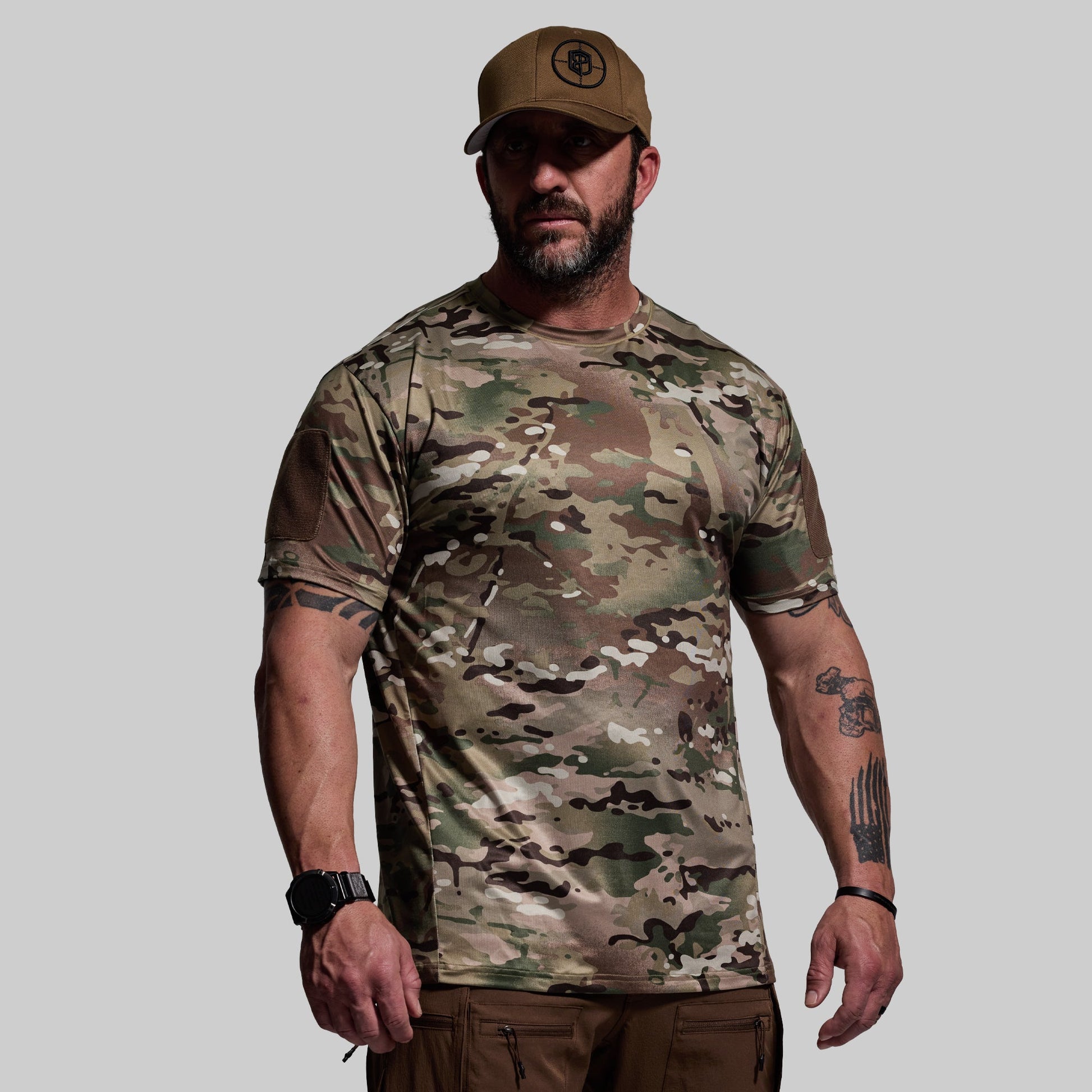 Man wearing a camouflage t-shirt and cap on a gray background