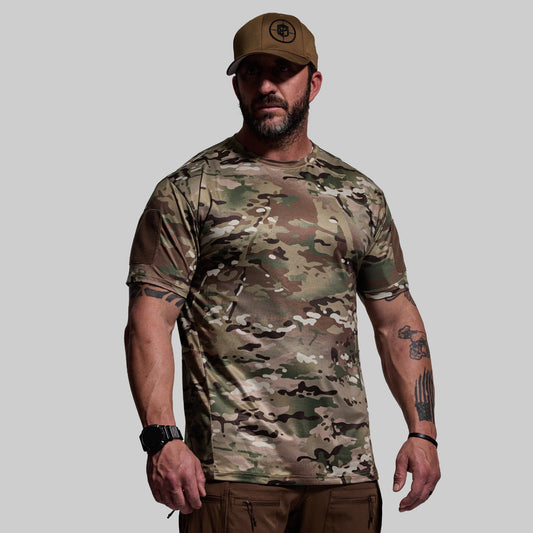 Man wearing a camouflage t-shirt and cap on a gray background