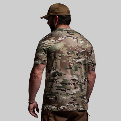 Person wearing a camouflage shirt and cap on a gray background