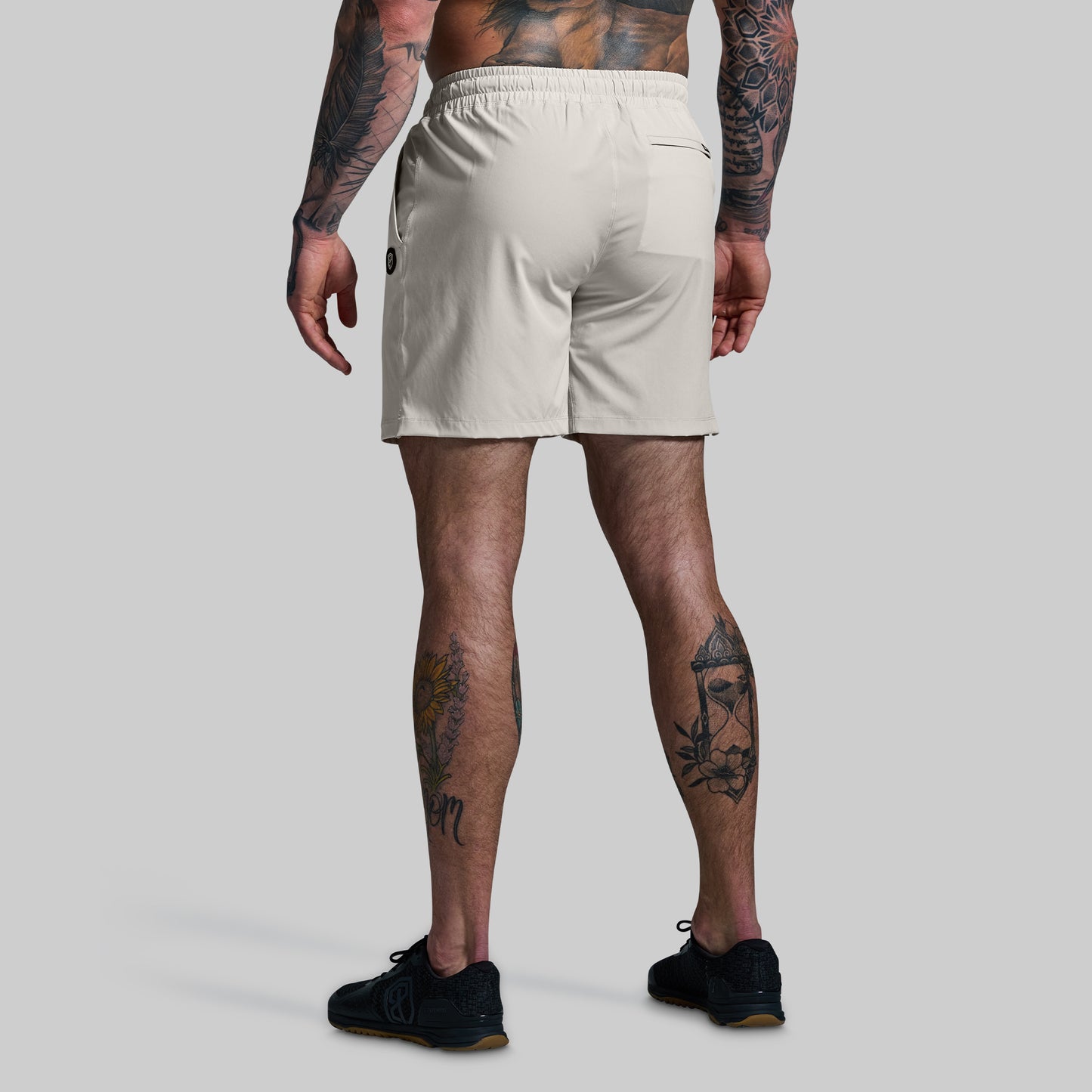 Person wearing beige shorts on a plain background